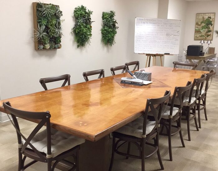Comfortable, well-lit counseling room at Creve Coeur Behavioral Counseling with a large wooden table, chairs, whiteboard, and soothing wall decor.